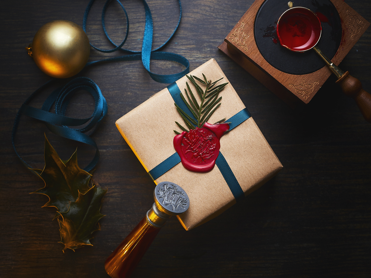 Wrapped Christmas gifts with wax seal showing jewellery engraving design